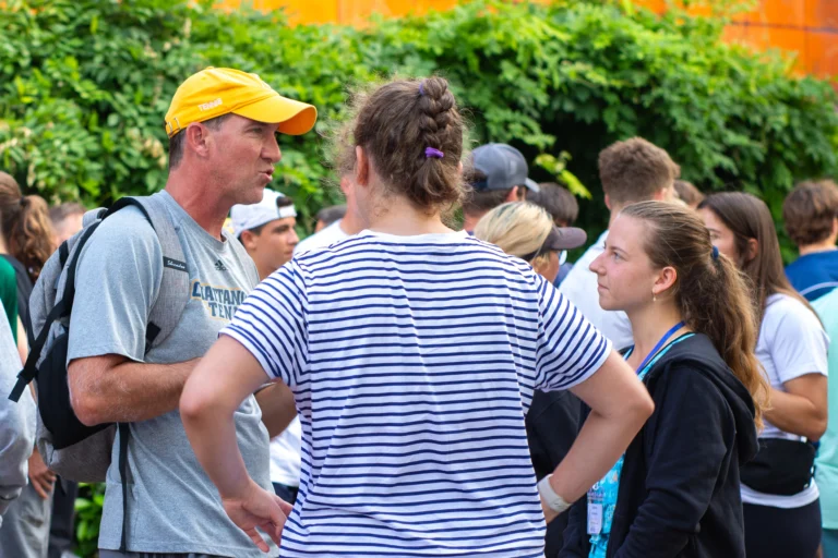 College coach talking with players at college tennis showcase