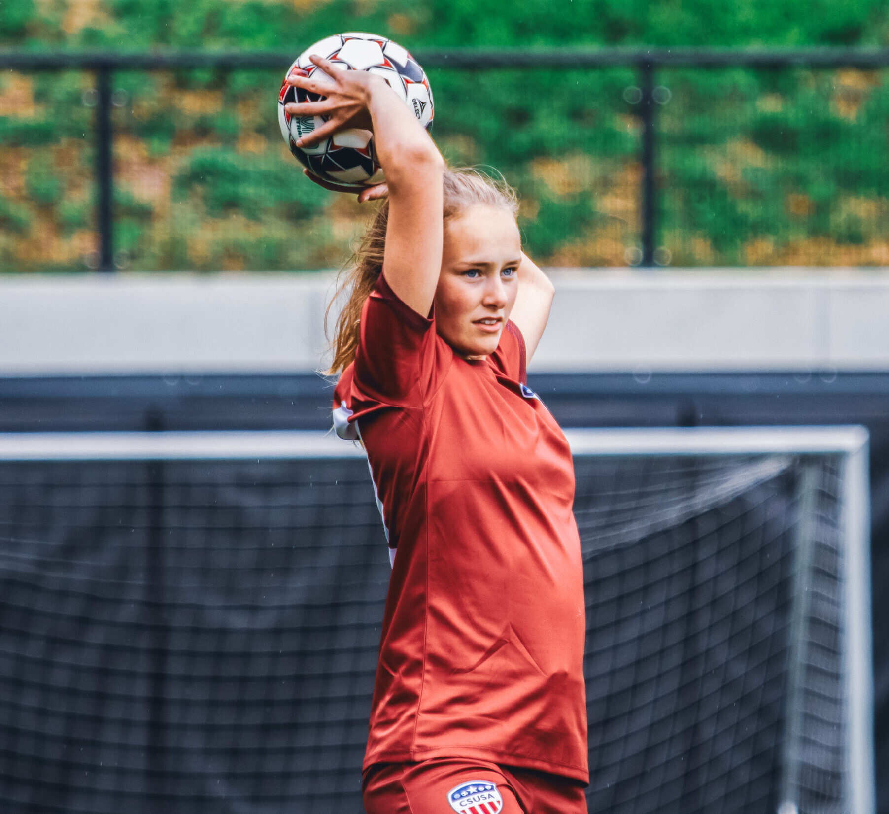 Soccer player throwing the ball with her hands