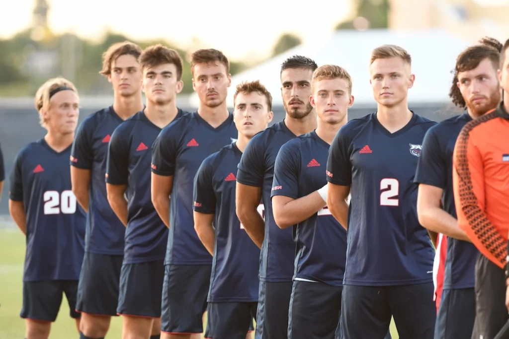 College Fußballteam steht zur Nationalhymne bereit.